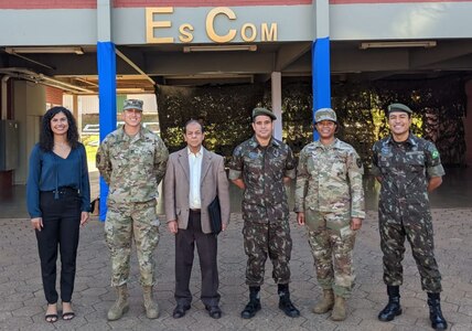 New York National Guard cyber protection experts Capt. Andrew Carter, the information systems officer for the 42nd Infantry Division headquarters battalion, second from left,  and Chief Warrant Officer 2 Nefertiti Stokes, a member of the 173rd Cyber Protection Team, second from right, with Brazilian counterparts during a visit to the Brazilian military communications school in Brasilia, Brazil, Aug.17, 2022. The Americans took part in Brazil’s annual Cyber Guardian Exercise as part of the New York National Guard State Partnership Program relationship with Brazil.