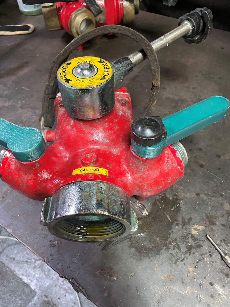 Members serving aboard the Coast Guard Cutter Venturous used a 3D printer to replace broken and cracked handles on the Y-gate, which is a part which allows a fireplug to feed two separate hoses. The handles are used to direct the flow of water. (U.S. Coast Guard photo.)