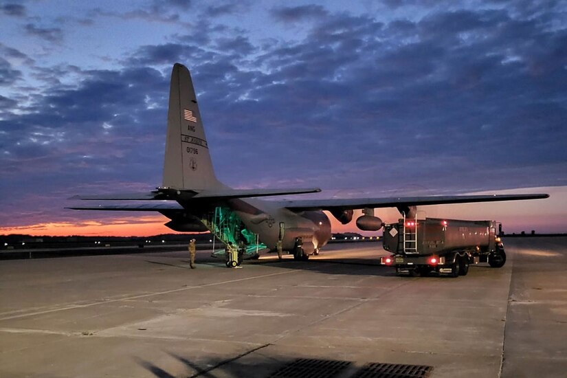 A large aircraft sits on the tarmac at twilight.