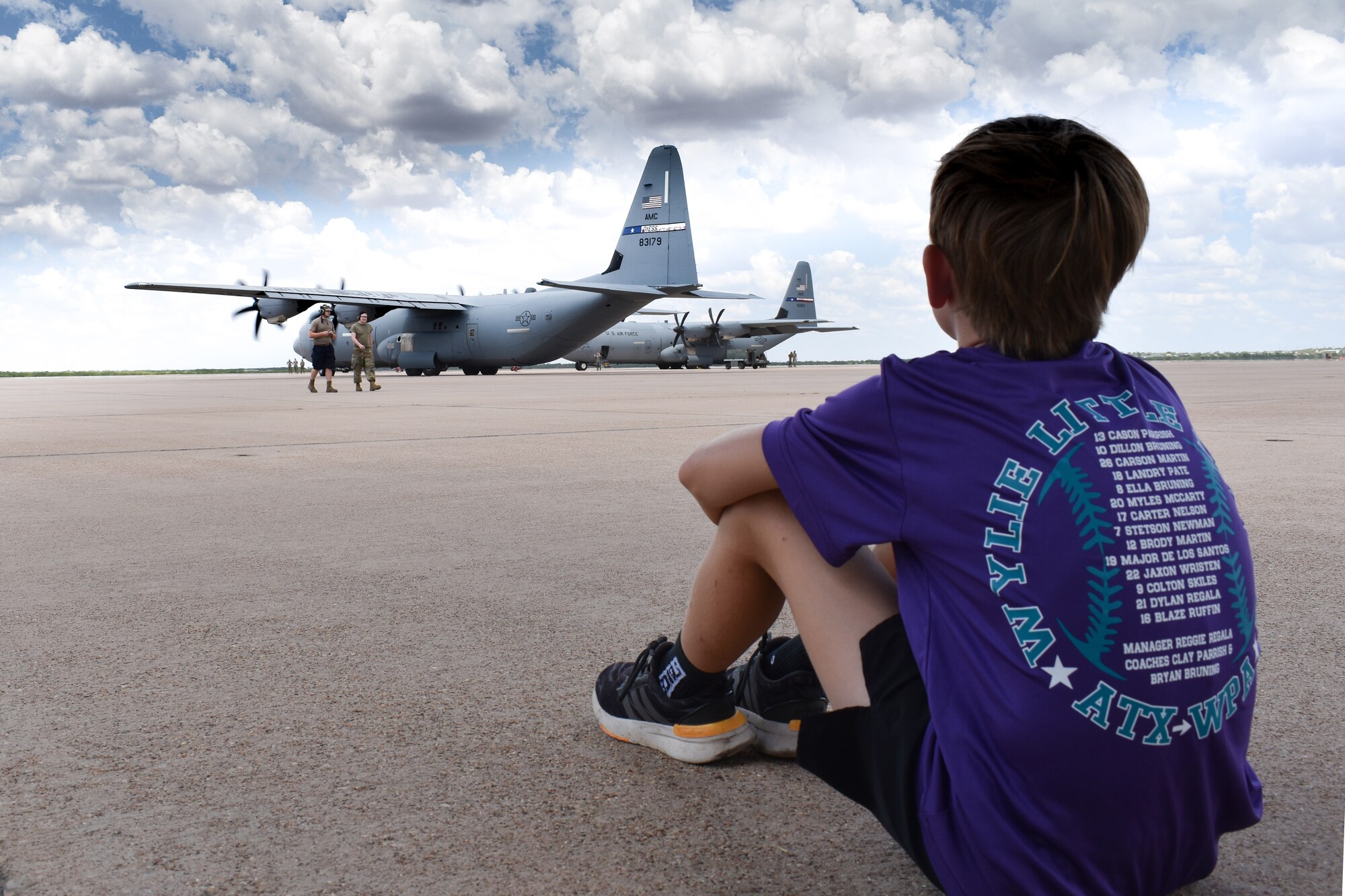 A member of the Wylie Little League Baseball team watches C-130 maintainers taxi aircraft while on a tour of Dyess Aug. 26, 2022. The C-130 unit’s deployment to U.S. Central Command taskings marks the first implementation of the Air Force Generation model in Air Mobility Command. (U.S. Air Force photo by 1st Lt. Kaitlin Cashin)