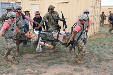 Air Force District of Washington medics litter carry a mock wounded soldier during a simulated combat zone scenario at the 2022 Medic Rodeo at Melrose Air Force Range, N.M., Aug. 17, 2022. The Medic Rodeo, hosted by the 27th Special Operations Wing, creates a ready medical force by testing the knowledge and skills of medics across the Air Force. (U.S. Air Force photo by 2nd Lt. Brandon DeBlanc)