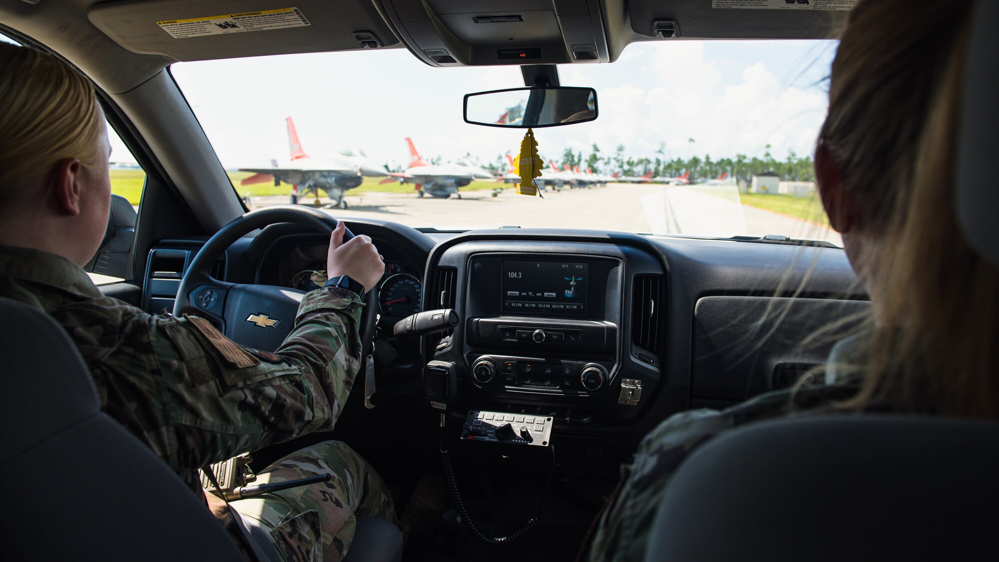 Airmen ride in a truck.