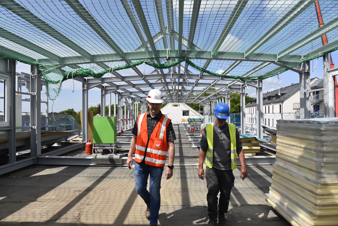 U.S. Army Corps of Engineers, Europe District Project Engineer Chris Hood and a contractor discuss progress at ongoing administrative facility renovations on Smith Barracks in Baumholder, Germany May 17, 2022. In close partnership with U.S. Army Garrison Rheinland-Pfalz, the U.S. Army Corps of Engineers is managing the renovation of several facilities in Baumholder as well as infrastructure improvements to prepare for the relocation of rotational forces supporting U.S. Special Operations Command Europe moving from U.S. Army Garrison Stuttgart. (U.S. Army photo by Chris Gardner)