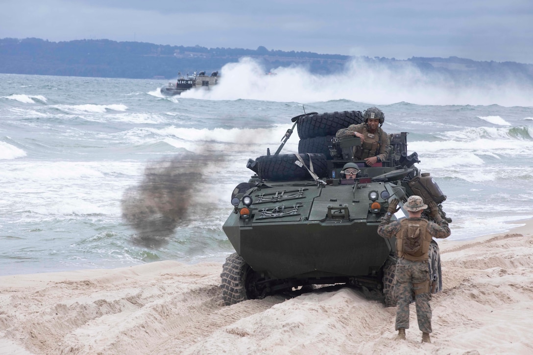 Baltic Sea (Aug. 25, 2022) U.S. Navy Boatswain’s Mate 1st Class Rashaad Merritt, assigned to Beach Master Unit 2, signals Light Armored Vehicles assigned to the 22nd Marine Expeditionary Unit (MEU), during a U.S. – Sweden bilateral exercise, Aug. 25, 2022. Gunston Hall (LSD 44) is part of the Kearsarge Amphibious Ready Group and embarked 22nd MEU, under the command and control of Task Force 61/2, on a scheduled deployment in the U.S. Naval Forces Europe area of operations, employed by U.S. Sixth Fleet, to defend U.S. allied and partner interests. (U.S. Navy Photo by Mass Communication Specialist 3rd Class Keith Nowak)