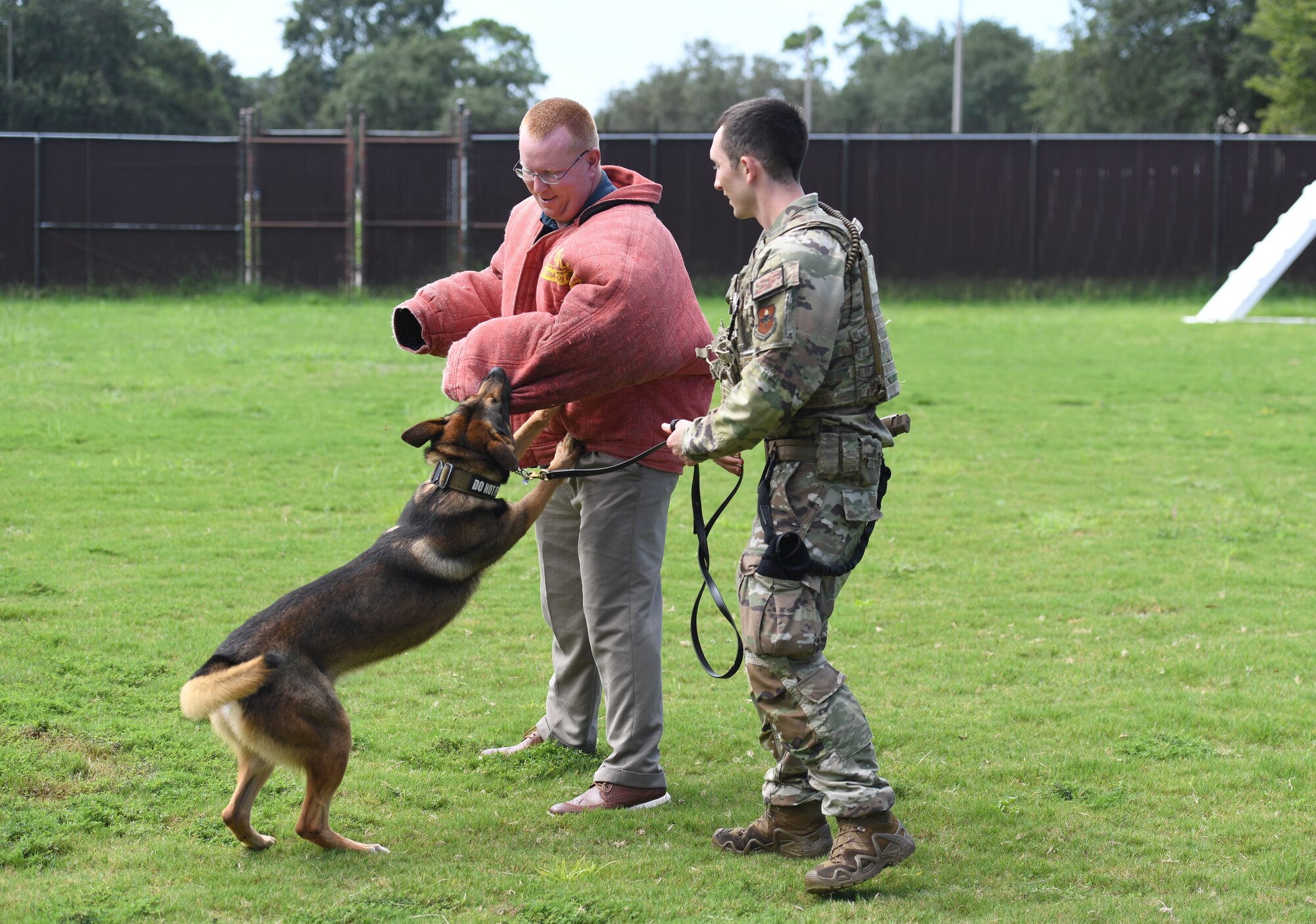 U.S. Air Force Staff Sgt. Dustin Hadsock, 81st Security Forces Squadron military working dog handler; Rico, 81st SFS military working dog, and Harry Weller, spouse of Lt. Col. Jennifer Weller, 336th Training Squadron commander, provide a demonstration at Keesler Air Force Base, Mississippi, Aug. 31, 2022. Keesler key spouses and spouses of base leadership toured a C-130J aircraft, the Keesler Medical Center and the Fisher House. (U.S. Air Force photo by Kemberly Groue)