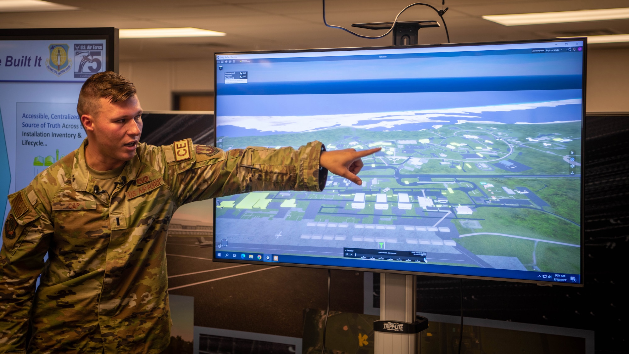 Uniformed Man points at screen.