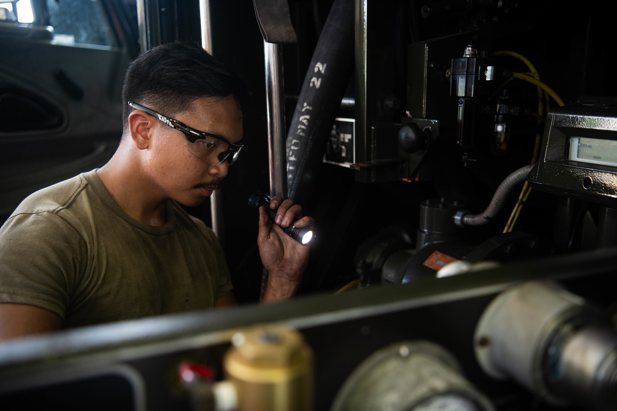 An Airman inspects a control board.