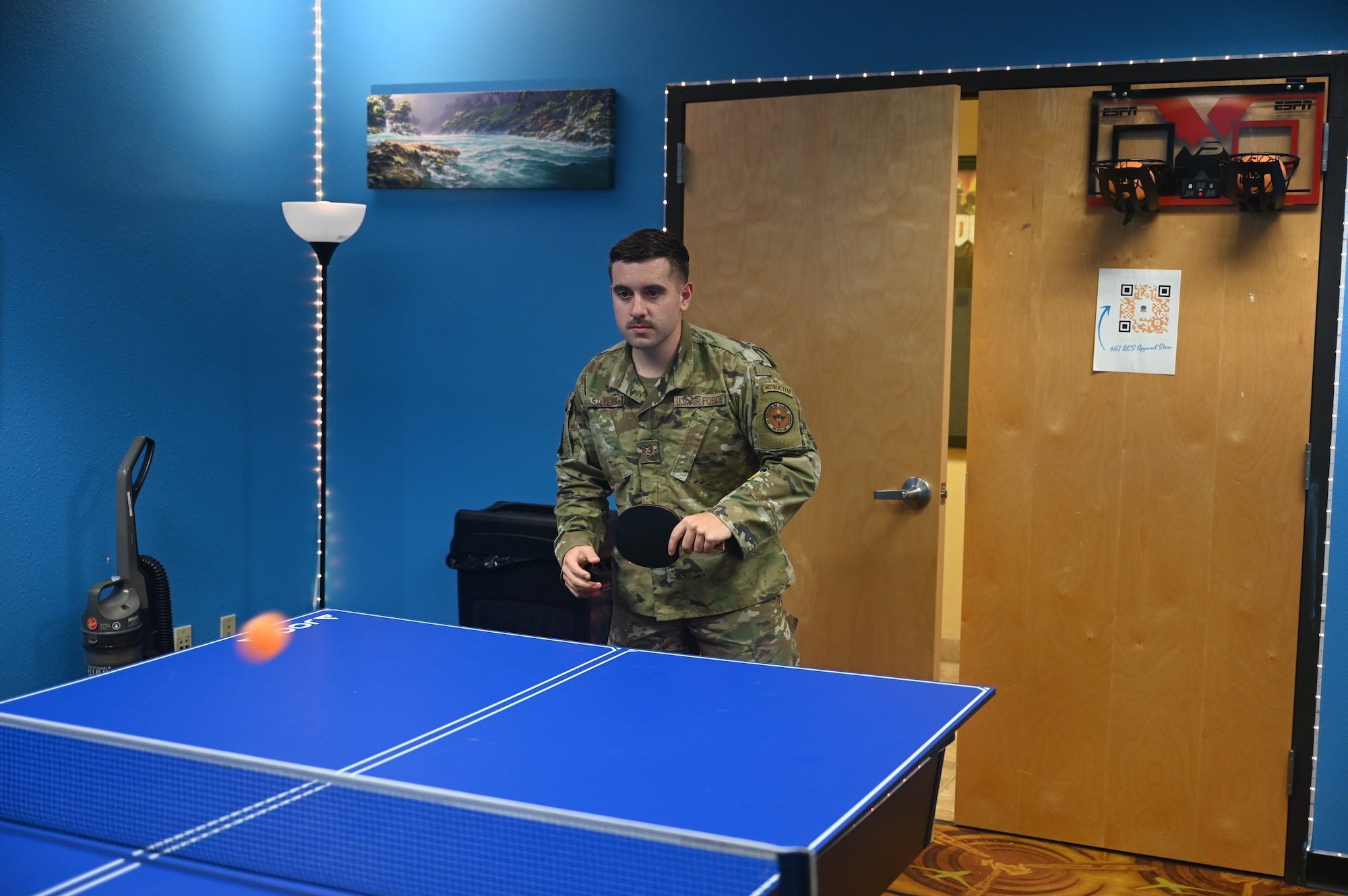 U.S. Air Force Staff Sgt. Howard Stevens, 607th Air Control Squadron weapons director, participates in a table tennis game in the newly opened 607th ACS Viper Den, August 22, 2022 at Luke Air Force Base, Arizona. The Viper Den was built to give Airmen a place to relax, unwind, and take a break from their duties, allowing them to stay focused on the mission.  (U.S. Air Force photo by Airman 1st Class Jakob Hambright)