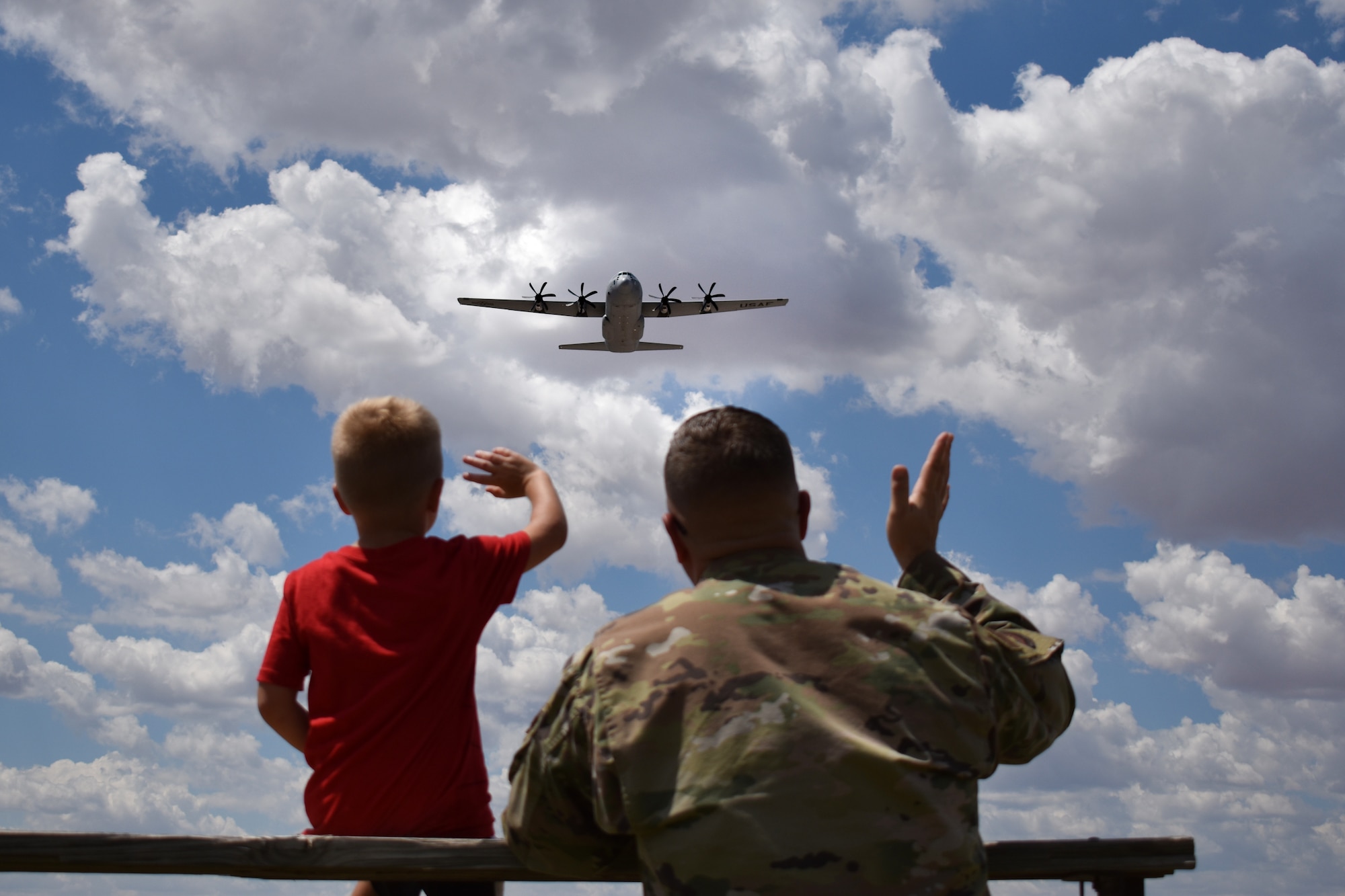A 317 AMXS Command Chief sits with his son and goodbye to the 39th Airlift Squadron C-130J they depart for a deployment to CENTCOM Aug. 26, 2022. The 317 AW rapid global mobility role will serve to enable the whole-of-coalition government actions to increase regional stability and support the fight against ISIS. (U.S. Air Force photo by 1st Lt. Kaitlin Cashin)