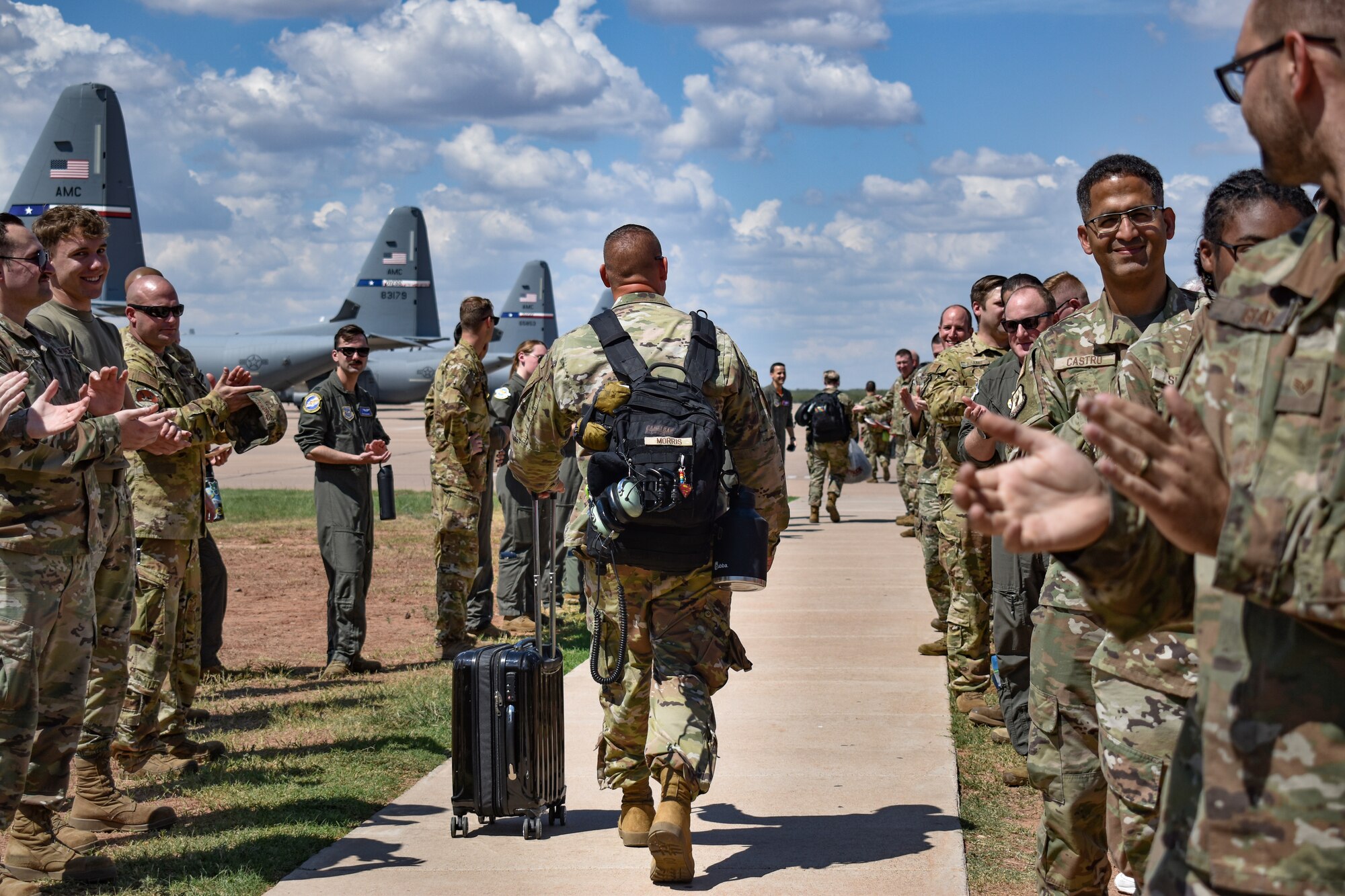 Members from the 317th Airlift Wing cheer on the 39th Airlift Squadron deployers as they process out to the Dyess flightline, Aug. 25, 2022. The C-130 unit’s deployment to U.S. Central Command taskings marks the first implementation of the Air Force Generation model in Air Mobility Command. The Air Force Force Generation model initially conceived by former Air Force Chief of Staff, Gen. David L. Goldfein, replacing the current Air Expeditionary Force construct to balance today’s combatant commander needs while building high-end readiness for the future. (U.S. Air Force photo by 1st Lt. Kaitlin Cashin)