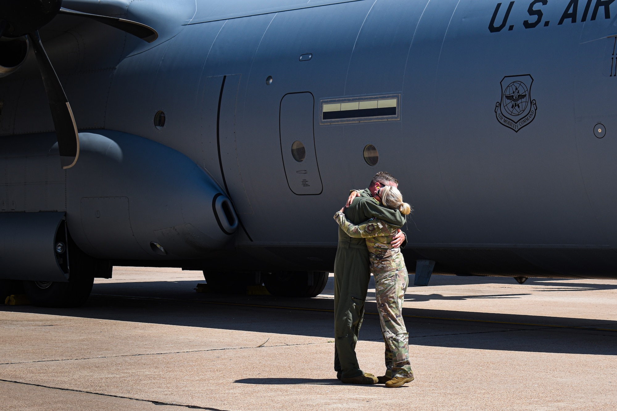 A military couple from the 317th Airlift Wing take one last embrace before the unit commander (right) boards a flight to CENTCOM. The C-130 unit’s deployment to U.S. Central Command marks the first implementation of the Air Force Generation model in Air Mobility Command. (U.S. Air Force photo by 1st Lt. Kaitlin Cashin)