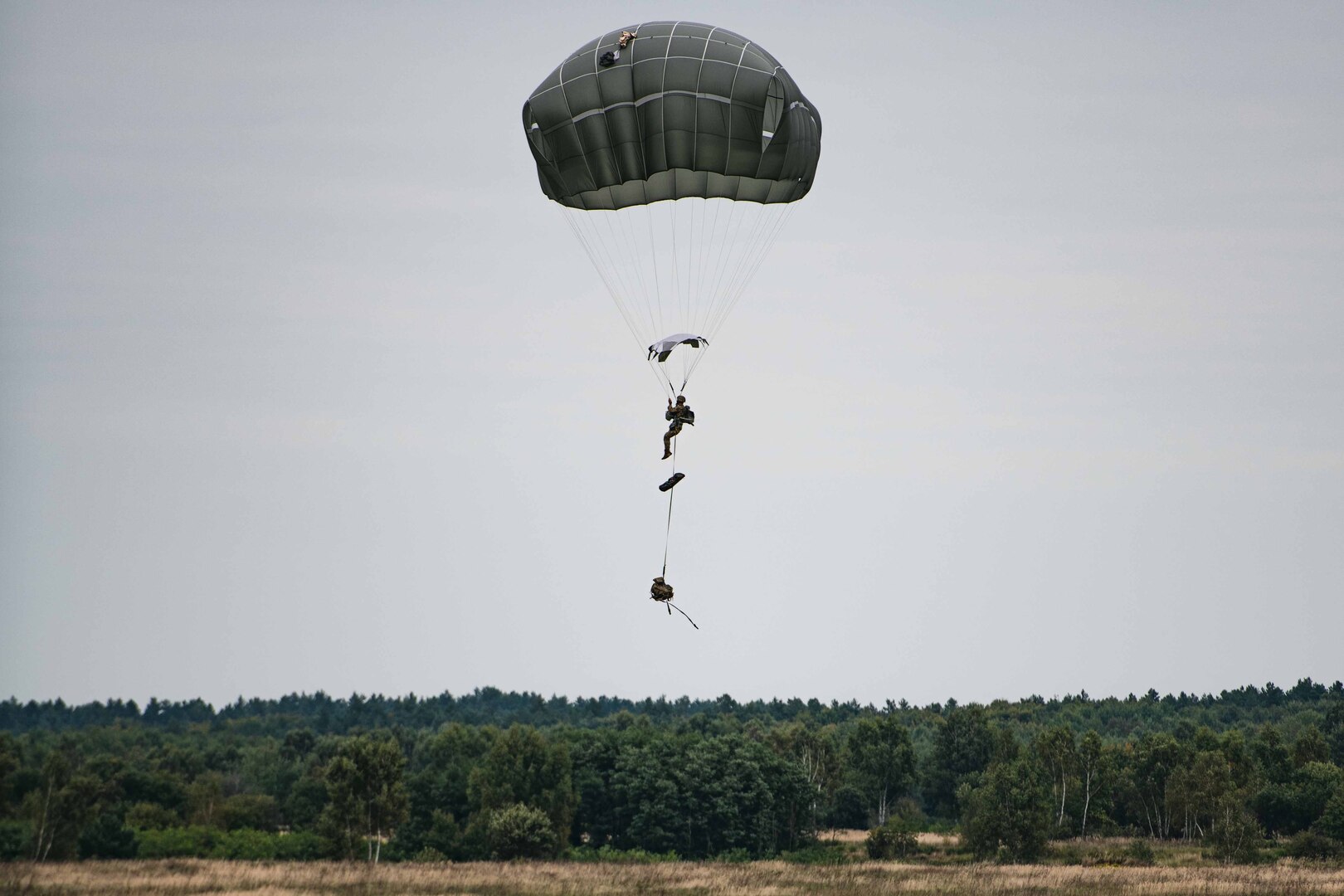 A parachuter drops from the sky.