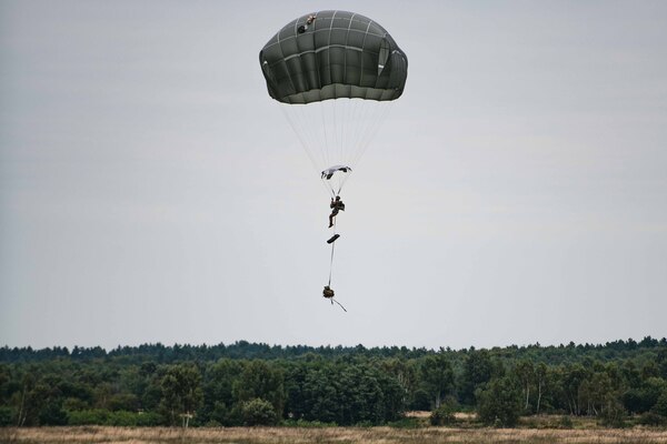 A parachuter drops from the sky.