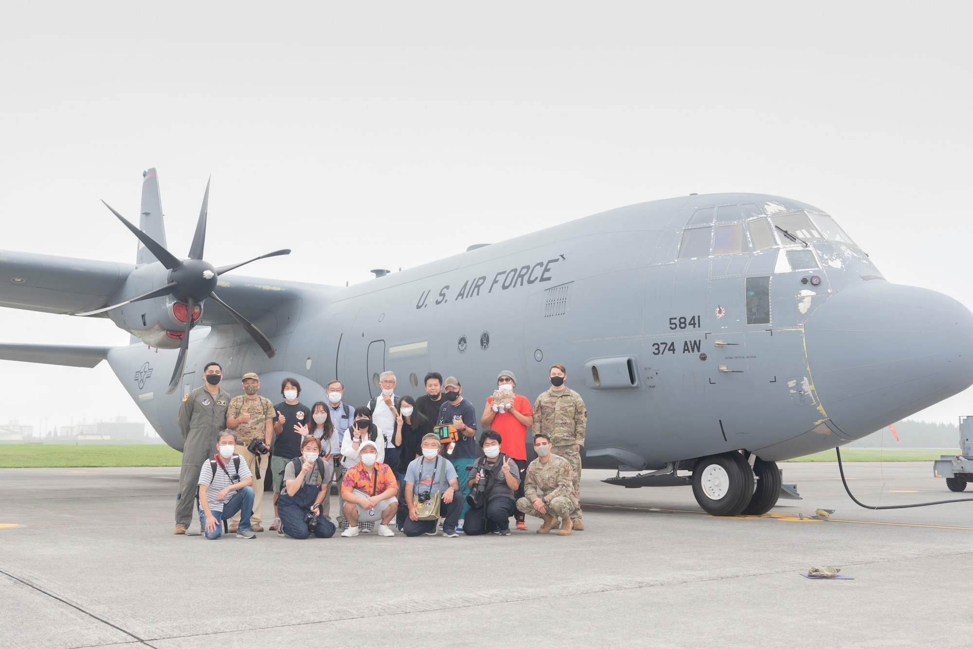 Airmen with 374th Airlift Wing and local Japanese aviation enthusiasts pose for a group photo during a tour at Yokota Air Base, Japan, Aug. 31, 2022.
