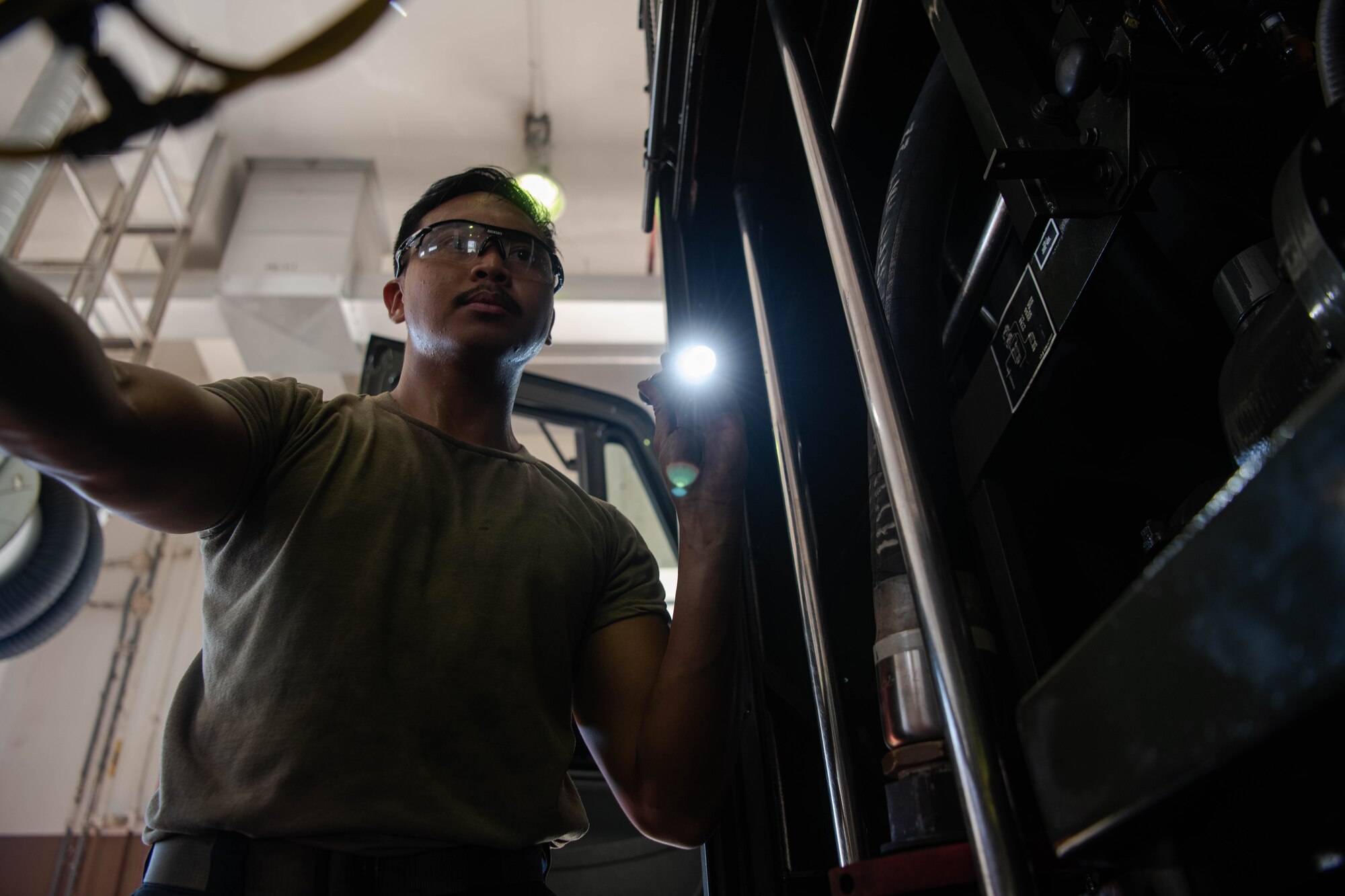 An Airman inspects a refueler control board's wiring.
