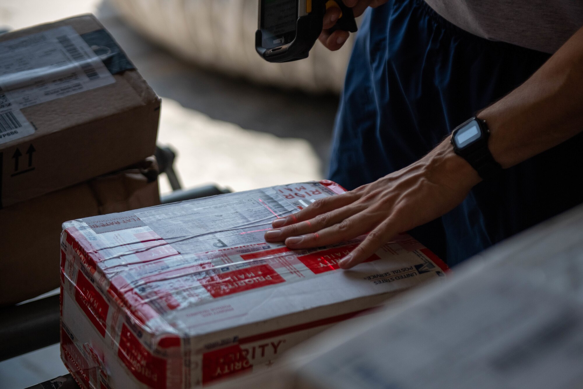 U.S. Air Force Airman 1st Class Anthony Manrrique, a military postal clerk with the 379th Expeditionary Force Support Squadron scans a package in the mail room at Al Udeid Air Base, Qatar, Sept. 1, 2022. Incoming mail is manually scanned and organized. (U.S. Air National Guard photo by Airman 1st Class Constantine Bambakidis)