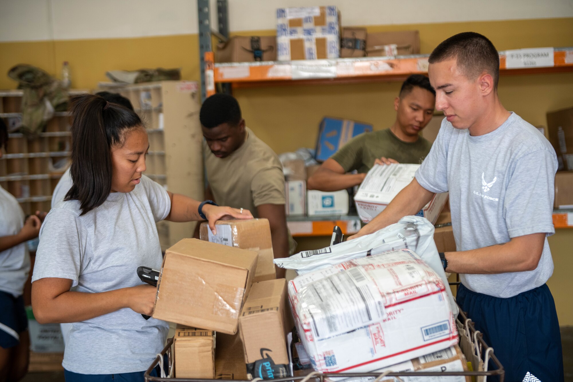 U.S. Air Force military postal clerks from the 379th Expeditionary Force Support Squadron, along with volunteers, scan and sort incoming mail at Al Udeid Air Base, Qatar, Sept. 1, 2022. Volunteers assist with unloading and sorting incoming mail. (U.S. Air National Guard photo by Airman 1st Class Constantine Bambakidis)