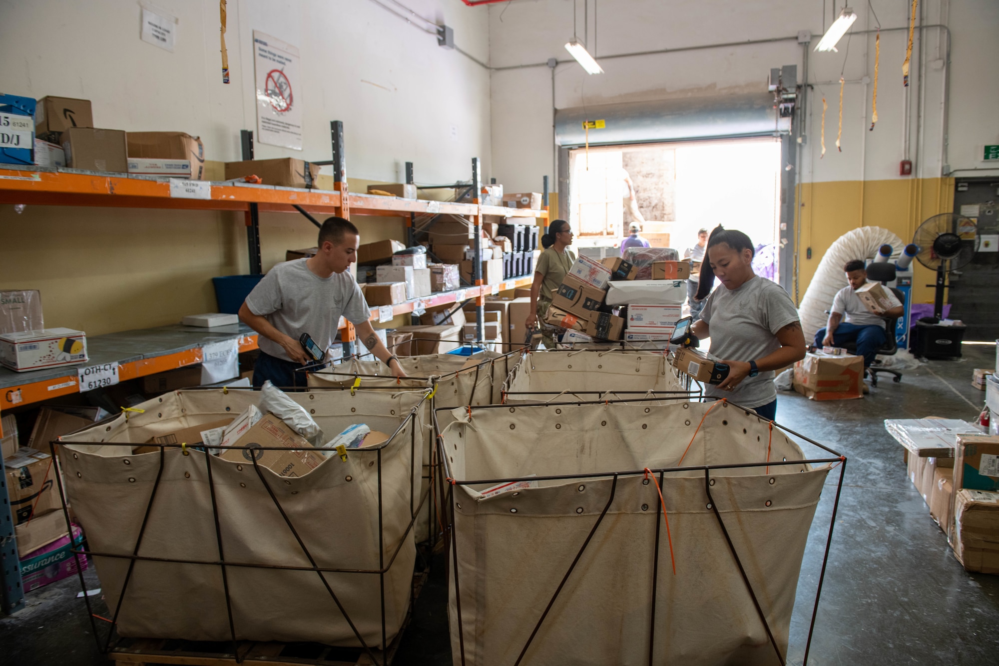 U.S. Air Force military postal clerks from the 379th Expeditionary Force Support Squadron organize incoming mail into bins at Al Udeid Air Base, Qatar, Sept. 1, 2022. Mail must be unloaded and organized every day. (U.S. Air National Guard photo by Airman 1st Class Constantine Bambakidis)
