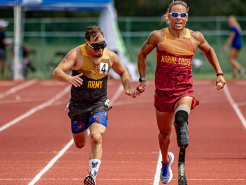 Retired U.S. Army Staff Sgt. Michael Murphy, left, is guided by U.S. Marine Sgt. Peter Keating while competing in a track event during the 2022 Department of Defense Warrior Games at the ESPN Wide World of Sports Complex in Orlando, Florida, Aug. 25, 2022. Hosted by the U.S. Army, service members and veterans from across the DoD compete in adaptive sports alongside armed forces competitors from Canada and Ukraine