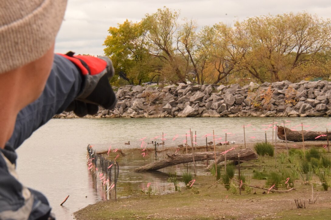 Andrew Hannes, biologist with U.S. Army Corps of Engineers (USACE) Buffalo District, points to a diked and ponded area where plants are growing on newly placed dredged material