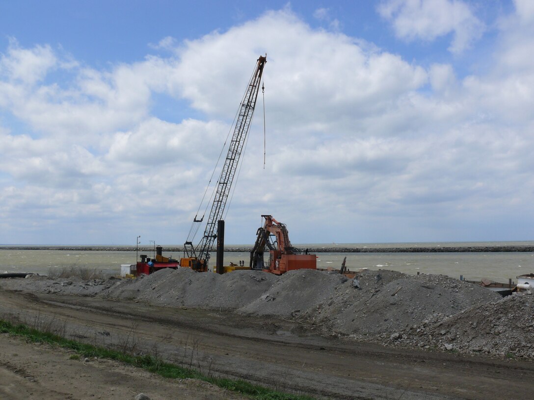 Ryba Marine Construction pump equipment sits along the Dike 12 wall with the Cleveland Breakwater in the background.