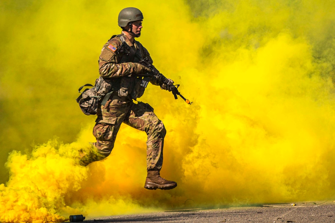 A guardsman runs through a haze of yellow smoke while holding a weapon.