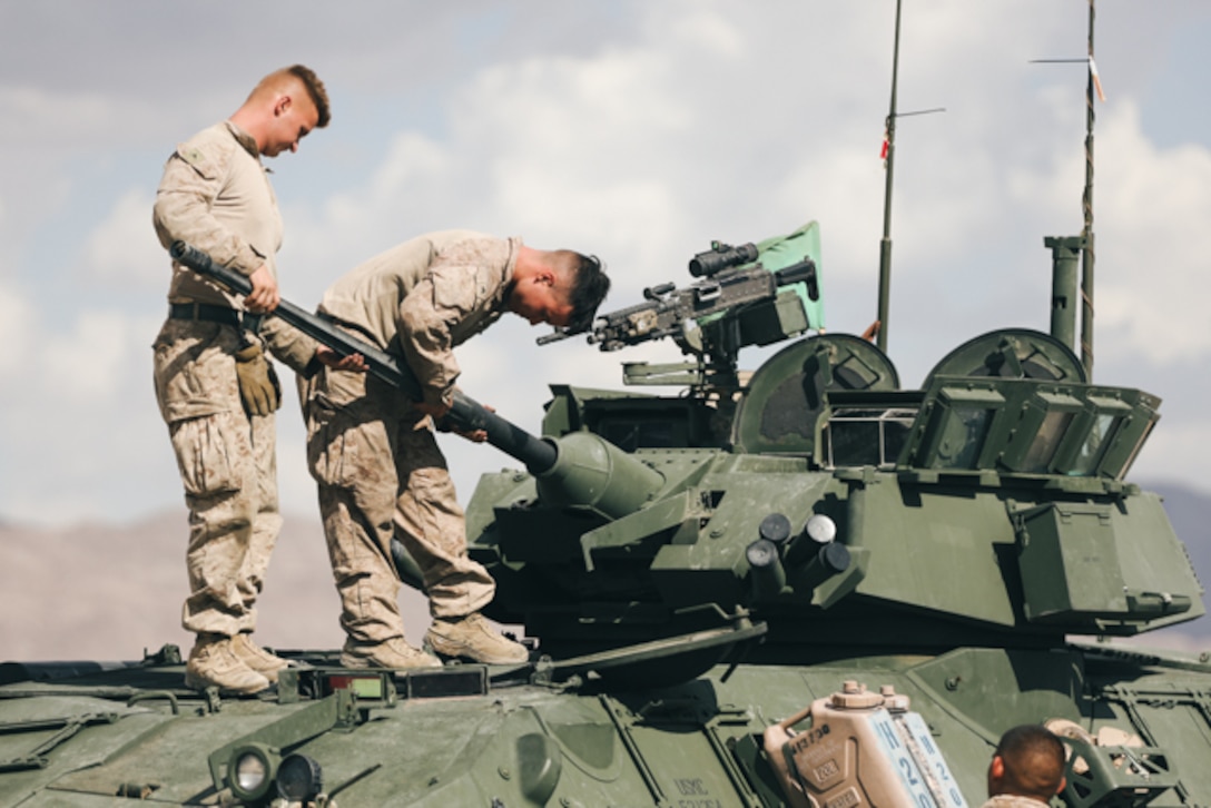 U.S. Marines with 3rd Light Armored Reconnaissance (LAR) Battalion, 1st Marine Division, attach a gun barrel to the M242 Bushmaster 25mm chain gun of a light armored vehicle (LAV) at Marine Corps Air Ground Combat Center, Twentynine Palms, California, Aug. 11, 2022. The Marines conducted LAV intermediate gunnery training for LAV crew qualifications. (U.S. Marine Corps photo by Lance Cpl. Andrew Bray)