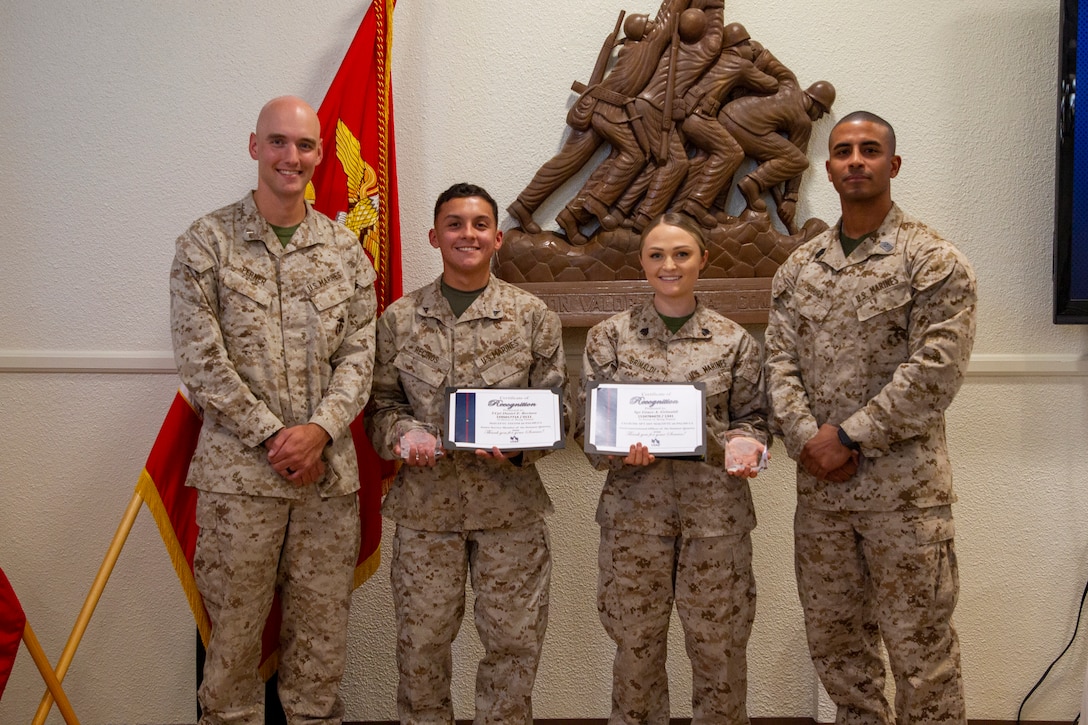 U.S. Marines (From left to right) 1st Lt. Bradley Ferner, company commander; Lance Cpl. Daniel Recinos, admin clerk; Sgt. Grace Grimaldi, platoon sergeant; and Sgt. Maj. Juan Segura, sergeant major; all with Headquarters Battalion, Marine Air Ground Task Force Training Command, Marine Corps Air Ground Combat Center (MCAGCC), pose for a photo during a Service Members of the Quarter Honoree Luncheon at MCAGCC, Twentynine Palms, California, Aug 31, 2022. The Armed Services YMCA hosted the luncheon to congratulate the honorees on their outstanding service. (U.S. Marine Corps photo by Lance Cpl. Jacquilyn Davis)