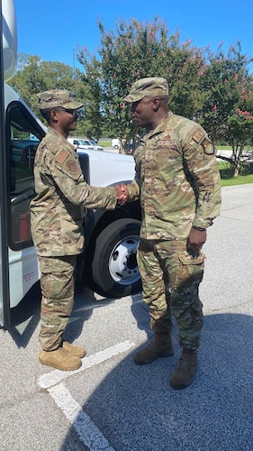 Photo shows two Airmen shaking hands