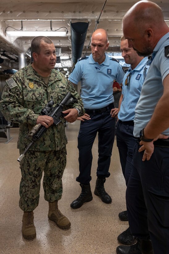 Chief Master-At-Arms Robert Abreu, assigned to the Spearhead-class expeditionary fast transport ship USNS Burlington (T-EPF-10), briefs Dutch military police while they tour the ship during a theater security cooperation event, Aug. 9, 2022. Burlington is deployed to the U.S. 4th Fleet area of operations to support expeditionary maintenance to deployed littoral combat ships operating in the region and conduct theater security cooperation engagements to maintain access, enhance interoperability and build enduring partnerships in the Caribbean, Central and South America.