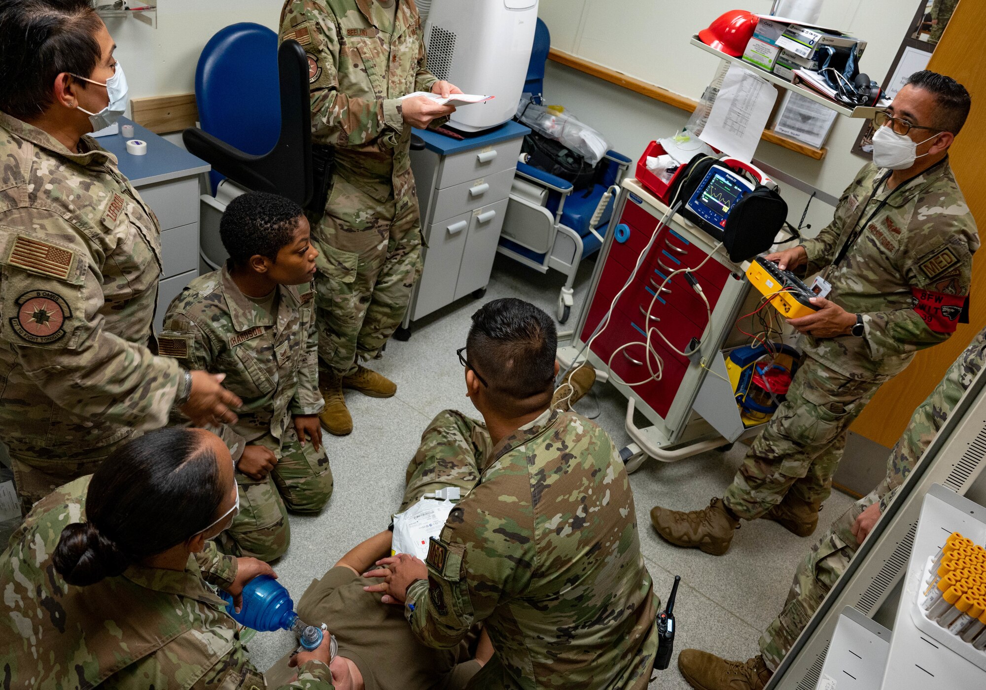 Airmen standing in room during medical emergency