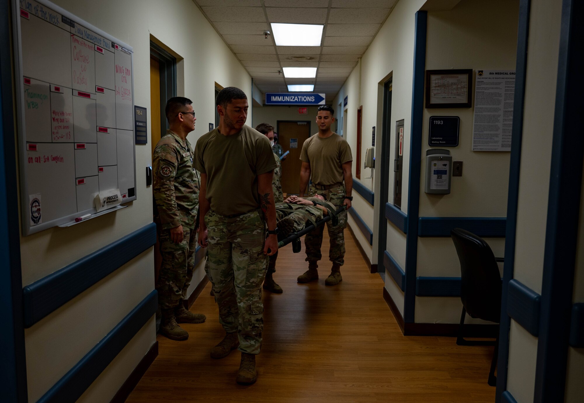 Airmen carry individual laying on stretcher.