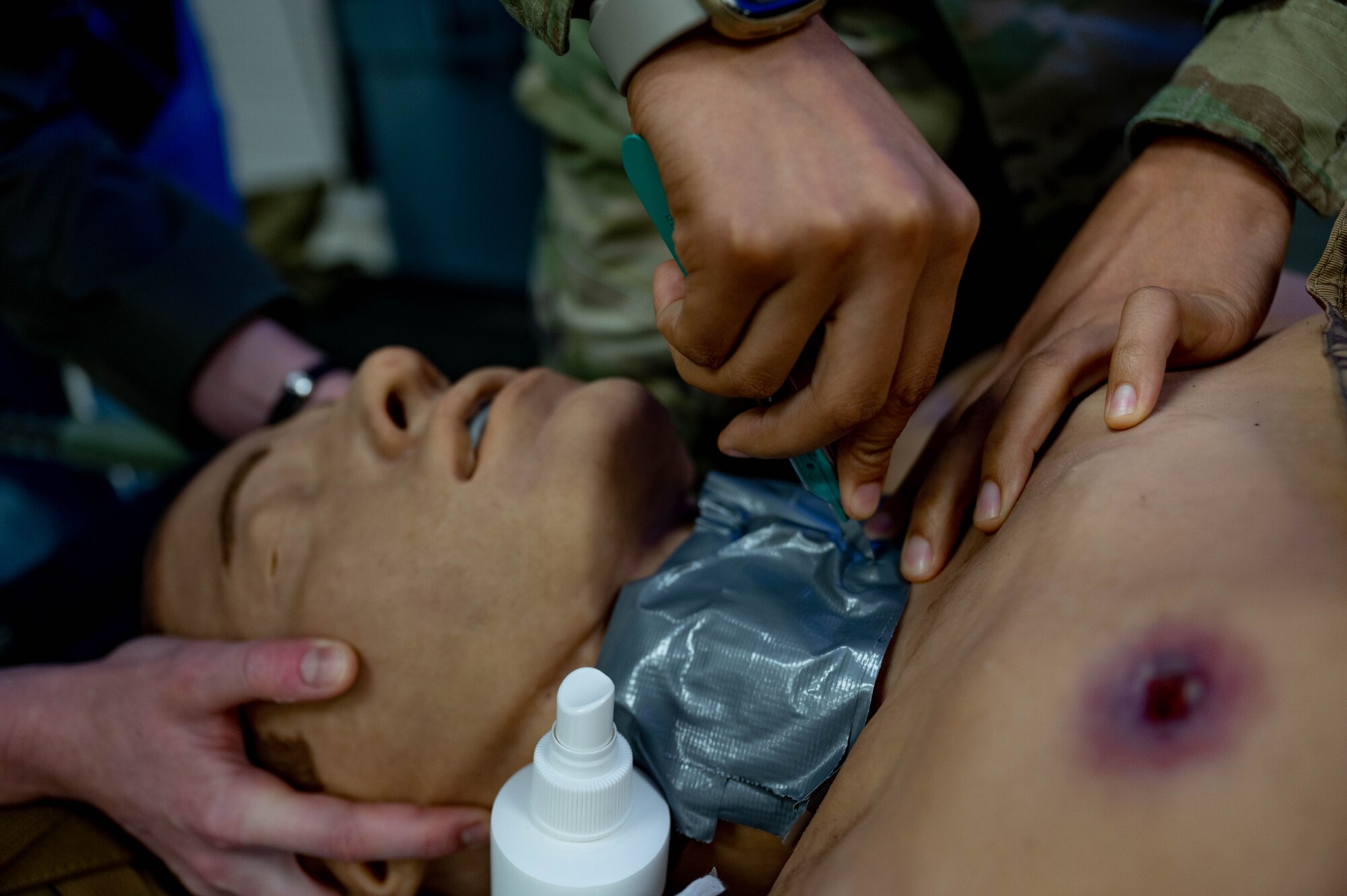 Airman cuts into medical manikin.