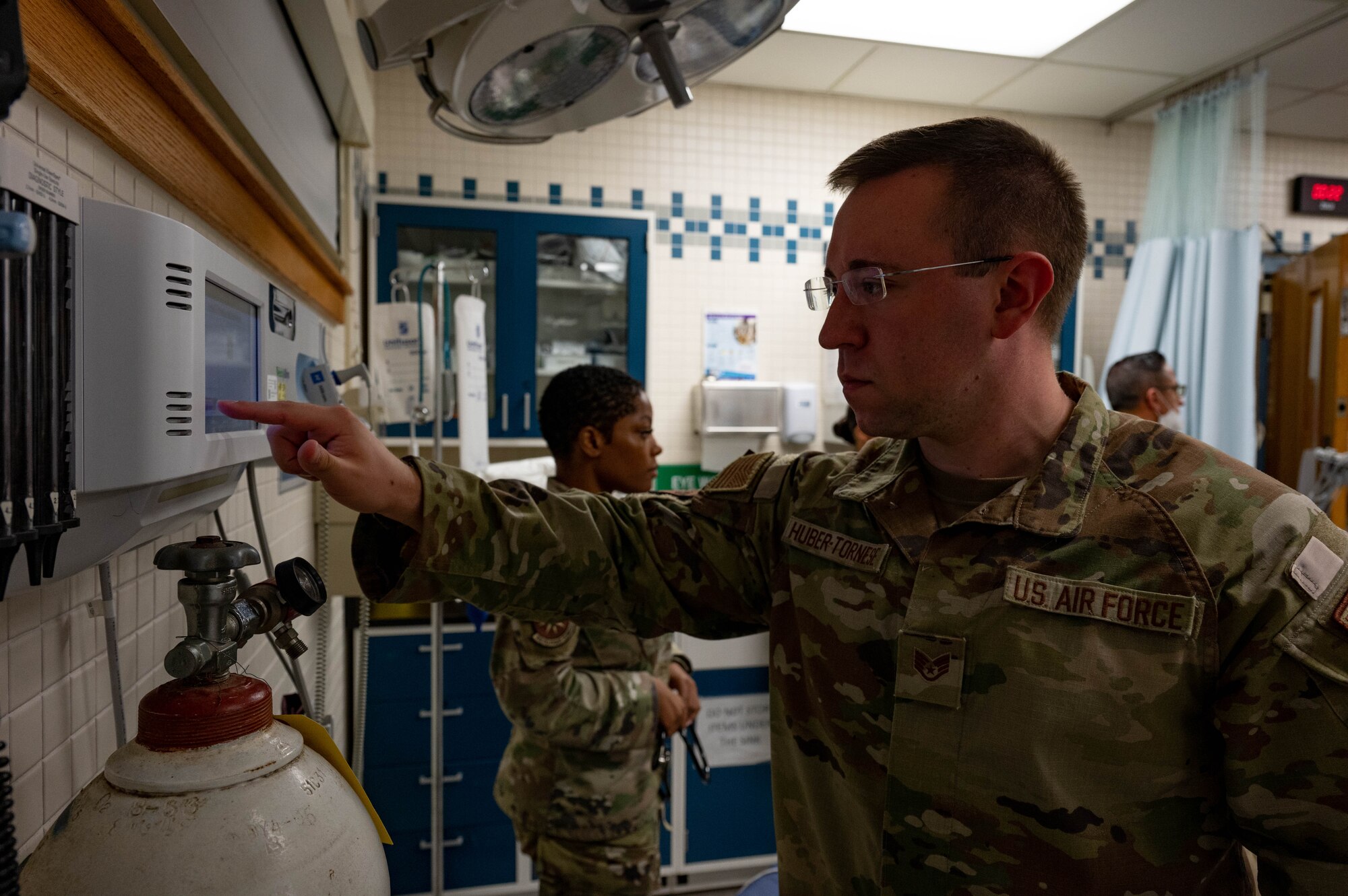Airman presses buttons on medical equipment.