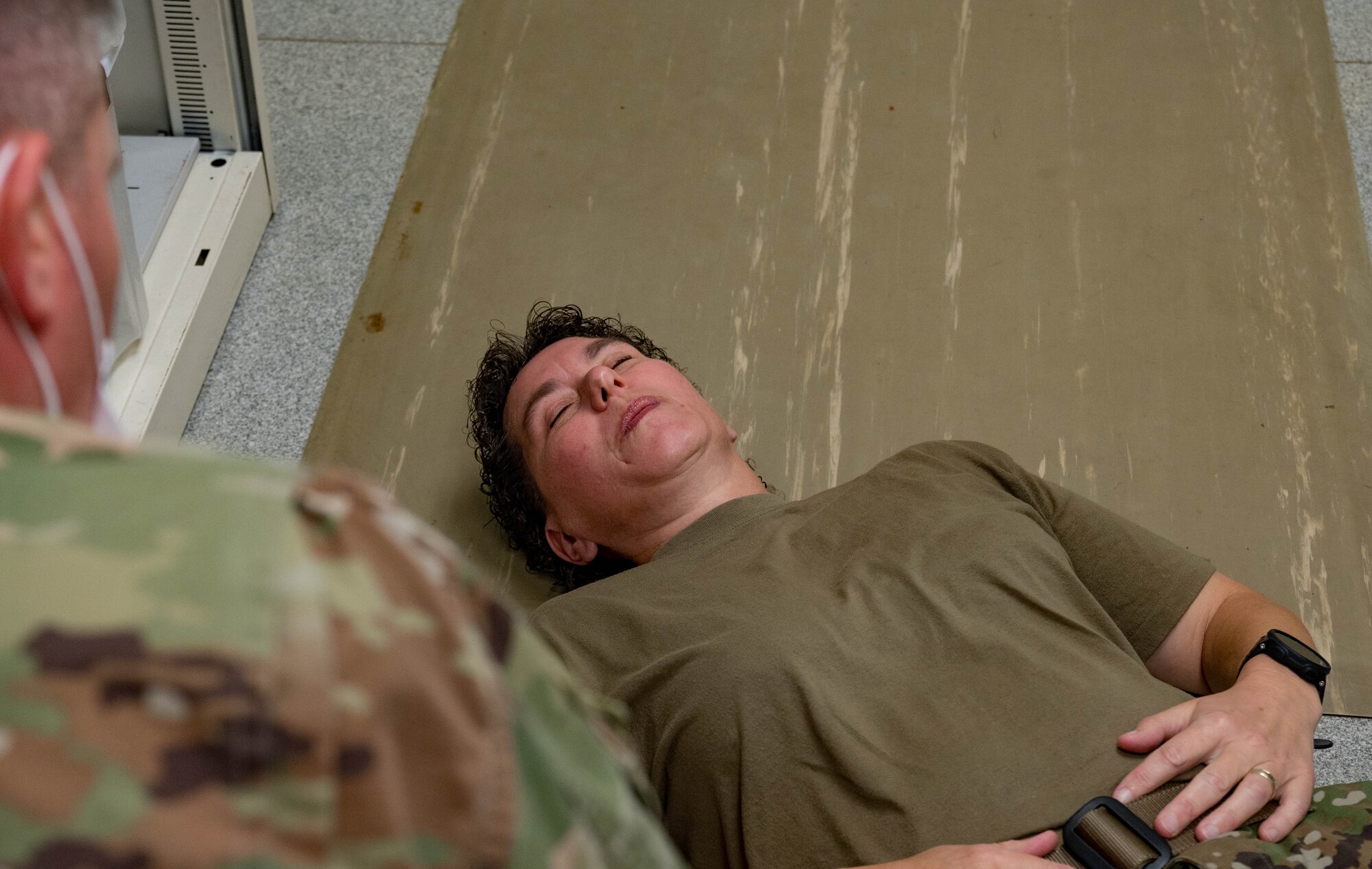 Airman looks over Airmen lying on ground.