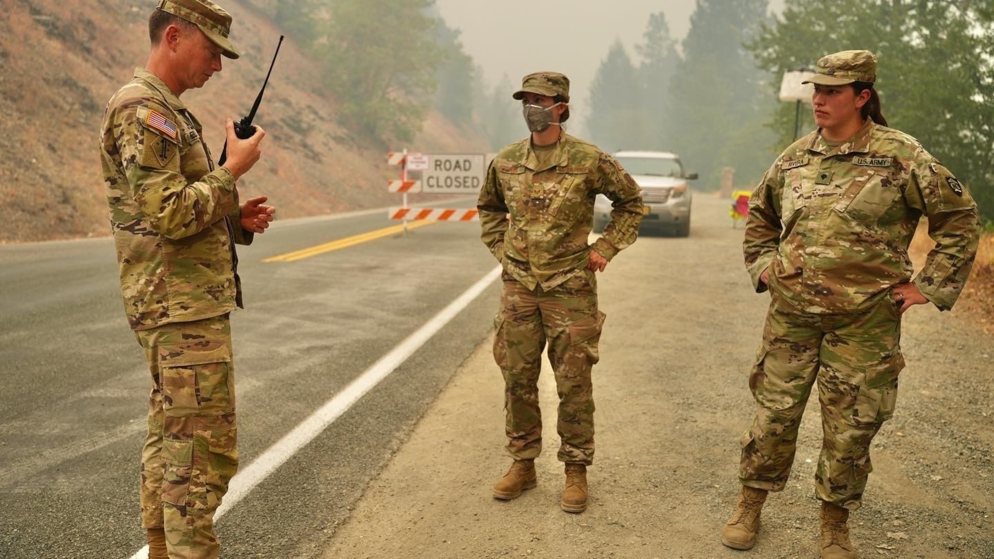 Deep in the Rum Creek Fire Complex area, Sgt. Jeremy Hensler conducts a radio check for Staff Sgt. Casey Reed and Spc. Britney Rivera at a road closure near Merlin, Ore. Sept. 2, 2022. Oregon National Guard members were supporting firefighting efforts at the Rum Creek wildfire.