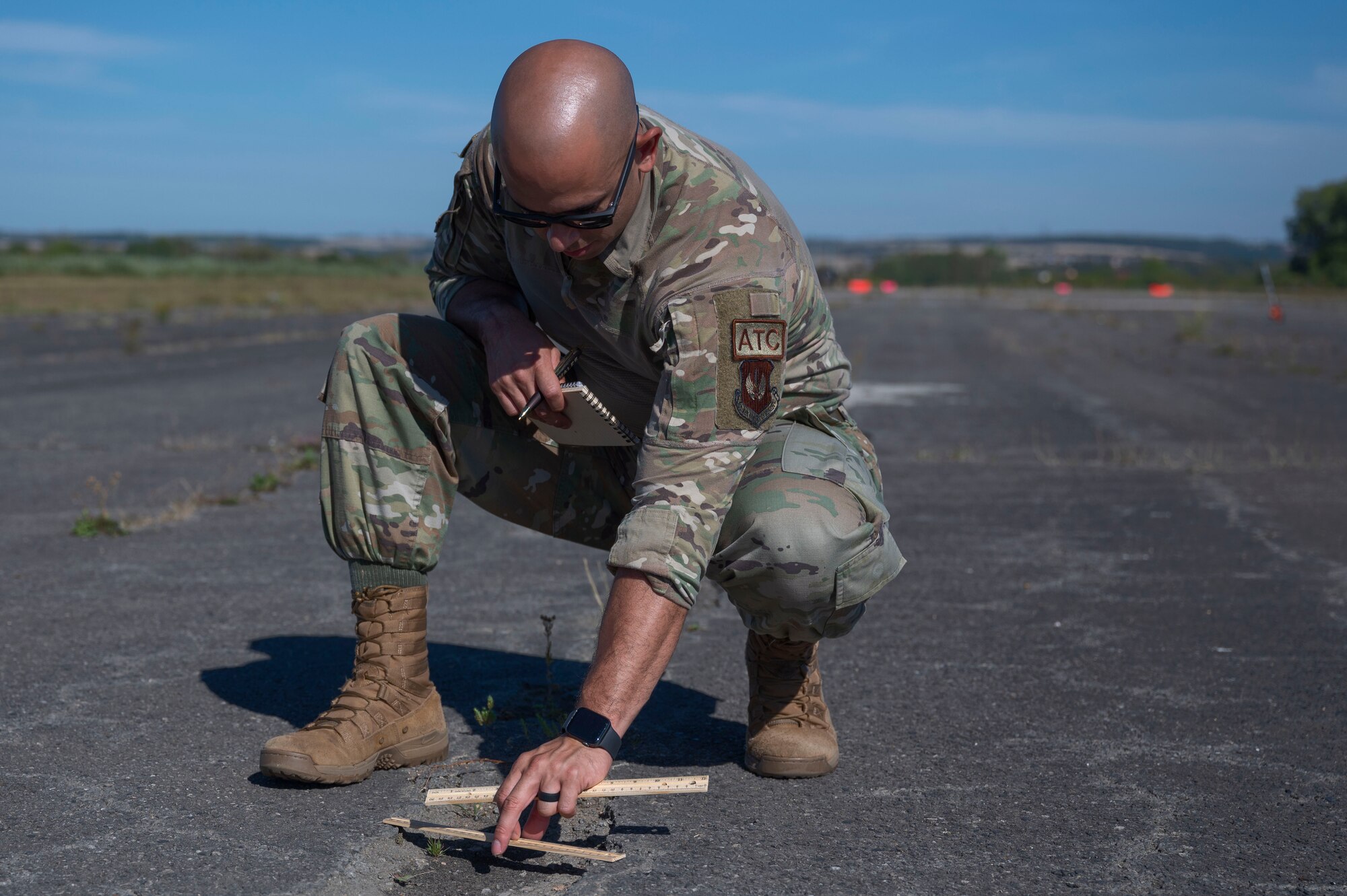 U.S. Air Force Master Sgt. Garrison Medina, 86th Operations Support Squadron, Air Traffic Control NCOIC Standards and Evaluations, measures discrepancies on an airfield at Base Aérienne Grostenquin, France, Aug. 26, 2022.