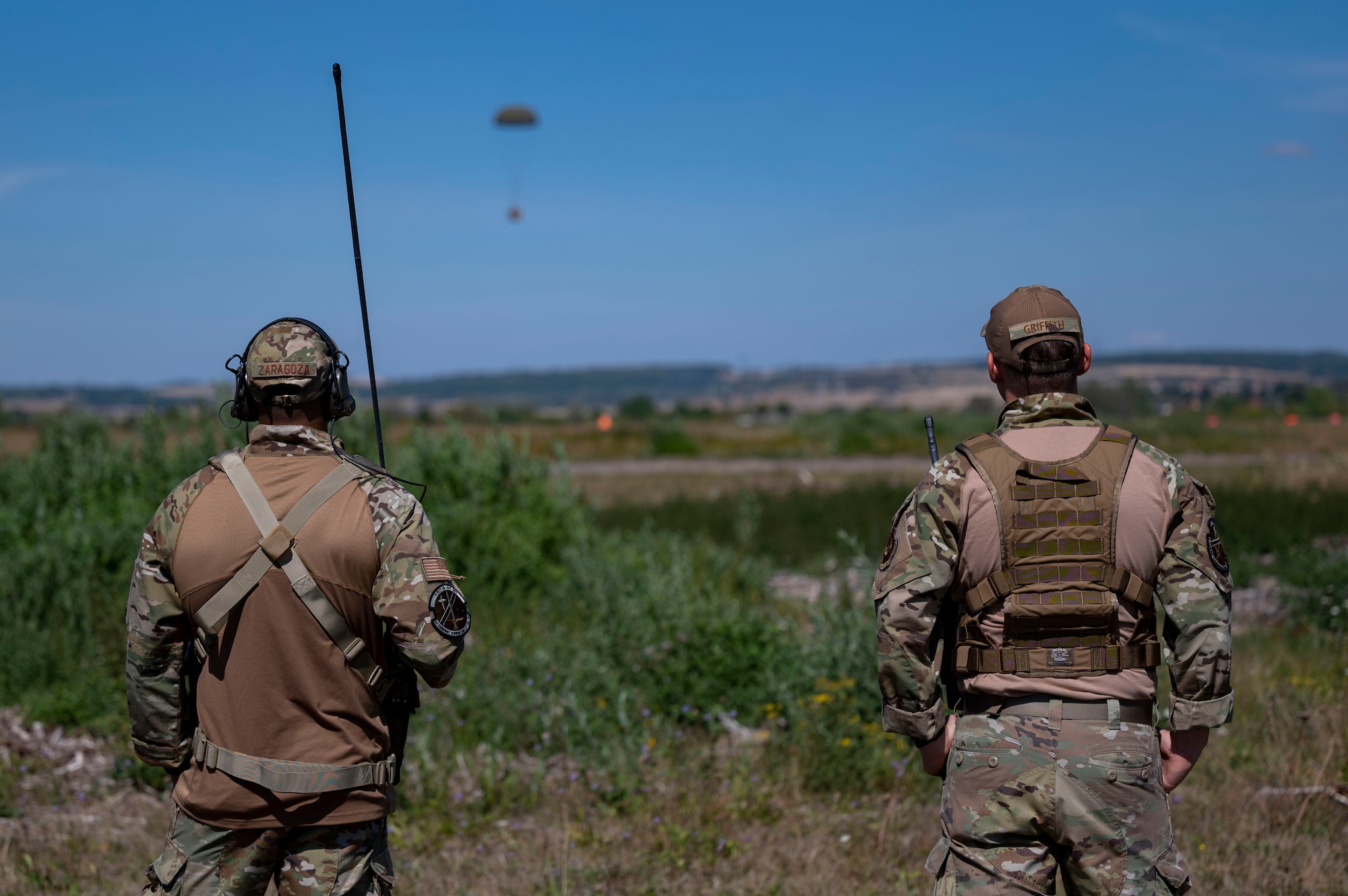 U.S. Air Force Master Sgt. Bruce Zaragoza, 1st Combat Communication Squadron Contingency Airfield Operations flight chief, and Staff Sgt. Patrick Griffith, 1st CBCS contingency air traffic controller, watch an airdrop at Base Aérienne Grostenquin, France, Aug. 26, 2022.