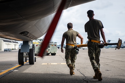 U.S. Air Force Airman 1st Class Blayne Delp, left, and Airman 1st Class Trevor Toshiba, right, 6th Maintenance Squadron aircraft propulsion apprentice and aircraft electrical and environmental systems apprentice, both from MacDill Air Force Base, Florida, carry a tow bar during the 6th Air Refueling Wing’s Agile Combat Employment capstone exercise at Joint Base Charleston, South Carolina, Aug. 25, 2022. The 6th MXS provides logistics management to support worldwide aerial refueling and special assignment missions. (U.S. Air Force photo by Airman 1st Class Christian Silvera)