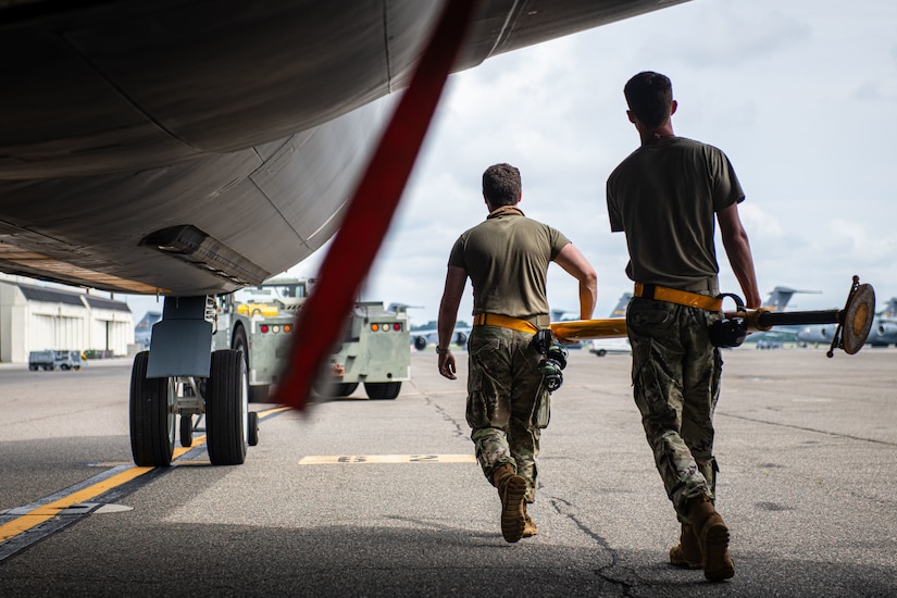 U.S. Air Force Airman 1st Class Blayne Delp, left, and Airman 1st Class Trevor Toshiba, right, 6th Maintenance Squadron aircraft propulsion apprentice and aircraft electrical and environmental systems apprentice, both from MacDill Air Force Base, Florida, carry a tow bar during the 6th Air Refueling Wing’s Agile Combat Employment capstone exercise at Joint Base Charleston, South Carolina, Aug. 25, 2022. The 6th MXS provides logistics management to support worldwide aerial refueling and special assignment missions. (U.S. Air Force photo by Airman 1st Class Christian Silvera)