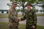 First Lt. Sven Pärand, a company commander in the Estonian Defense League, shakes hands with U.S. Army Staff Sgt. Joel Parham, scout squad leader from the 3-126th Infantry Regiment, at Camp Grayling, Michigan, while participating in the Military Reserve Exchange Program July 19-23, 2022.