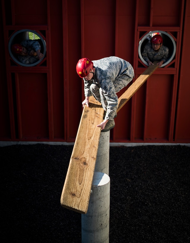 Airman 1st Class Zachary Hodges, 366th Component Maintenance Squadron precision measurement equipment laboratory technician, lays planks across concrete columns during a leadership reaction course at Gowen Field, Idaho, Sept. 29, 2017. Attendees were split into teams and each member was given a chance to lead their team across obstacles such as this one, where the objective was to get all team members and an ammunition can through the tunnels and across the pillars without touching the ground. (U.S. Air Force photo/Senior Airman Samuel Morse)