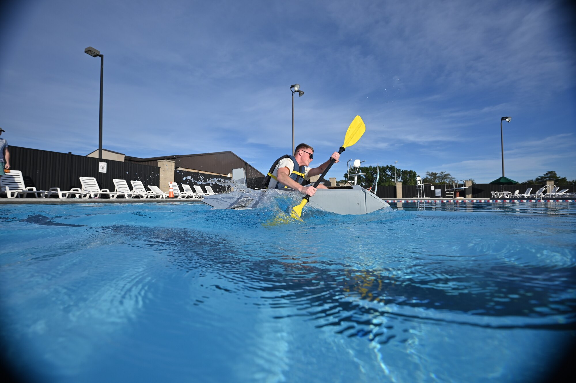 A Team Dover Airman paddles his boat during the Cardboard Boat Regatta at Dover Air Force Base, Delaware, Sept. 2, 2022. Three teams participated in the timed event and prizes were given for fastest time, most creative and most team spirit. (U.S. Air Force photo by Staff Sgt. Marco A. Gomez)