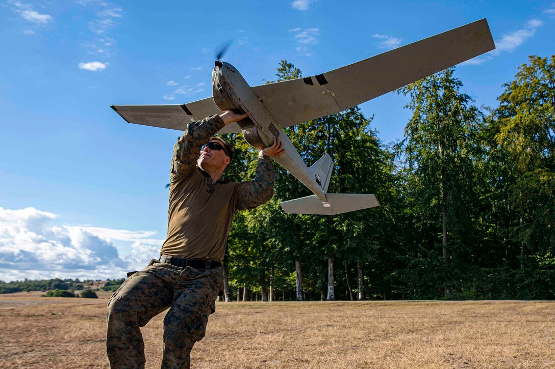 A Marine launches a small unmanned aircraft.