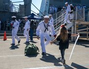 A Sailor assigned to Arleigh Burke-class guided-missile destroyer USS Momsen (DDG 92) reuintes with his family on pier at Naval Station Everett, Washington, Sept. 6. The Momsen, assigned to Carrier Strike Group Three, returned following a seven-month deployment to the U.S. 3rd, 5th and 7th Fleets in support of a free and open Indo-Pacific. (U.S. Navy photo by Mass Communication Specialist 2nd Class Ethan Soto)