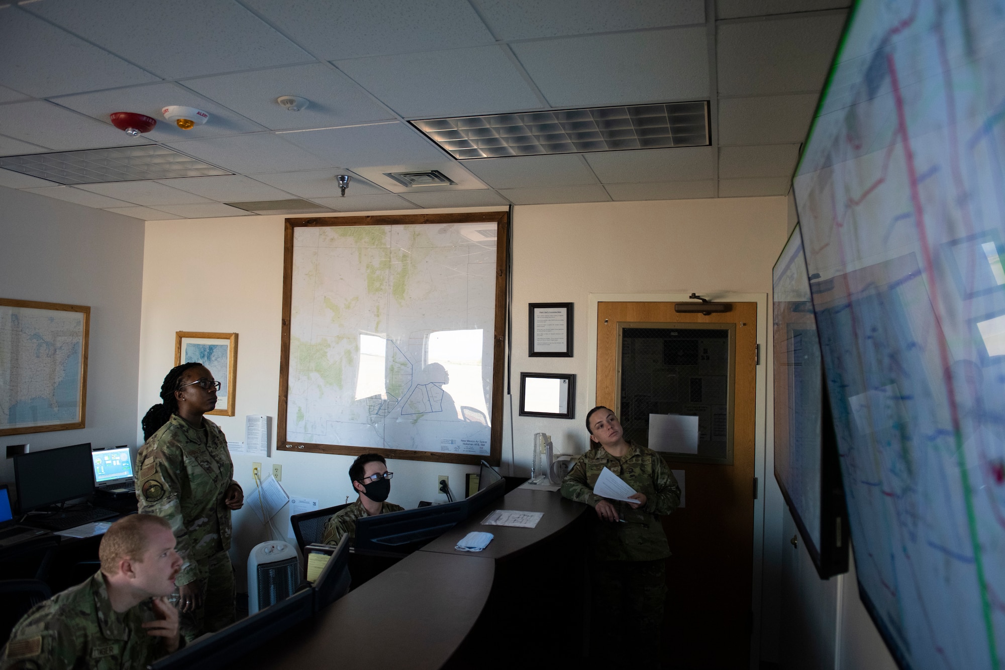 U.S. Air Force Airmen from the 54th Operations Support Squadron discuss weather conditions around the installation, Aug. 23, 2022, at Holloman Air Force Base, New Mexico. The 54th OSS provides the base with past, present and future weather observations that are crucial to providing the surrounding squadrons and units with air superiority. (U.S Air Force photo by Airman 1st Class Isaiah Pedrazzini)