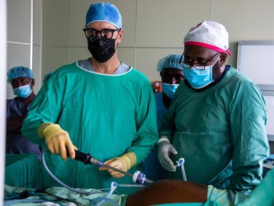 U.S. Navy Cmdr. Donald Lucas, from Dallas, left, and Michael Belande Buin, a general surgeon from the Solomon Islands, right, perform laparoscopic surgery on a local patient at the Gizo Medical Hospital during Pacific Partnership 2022.