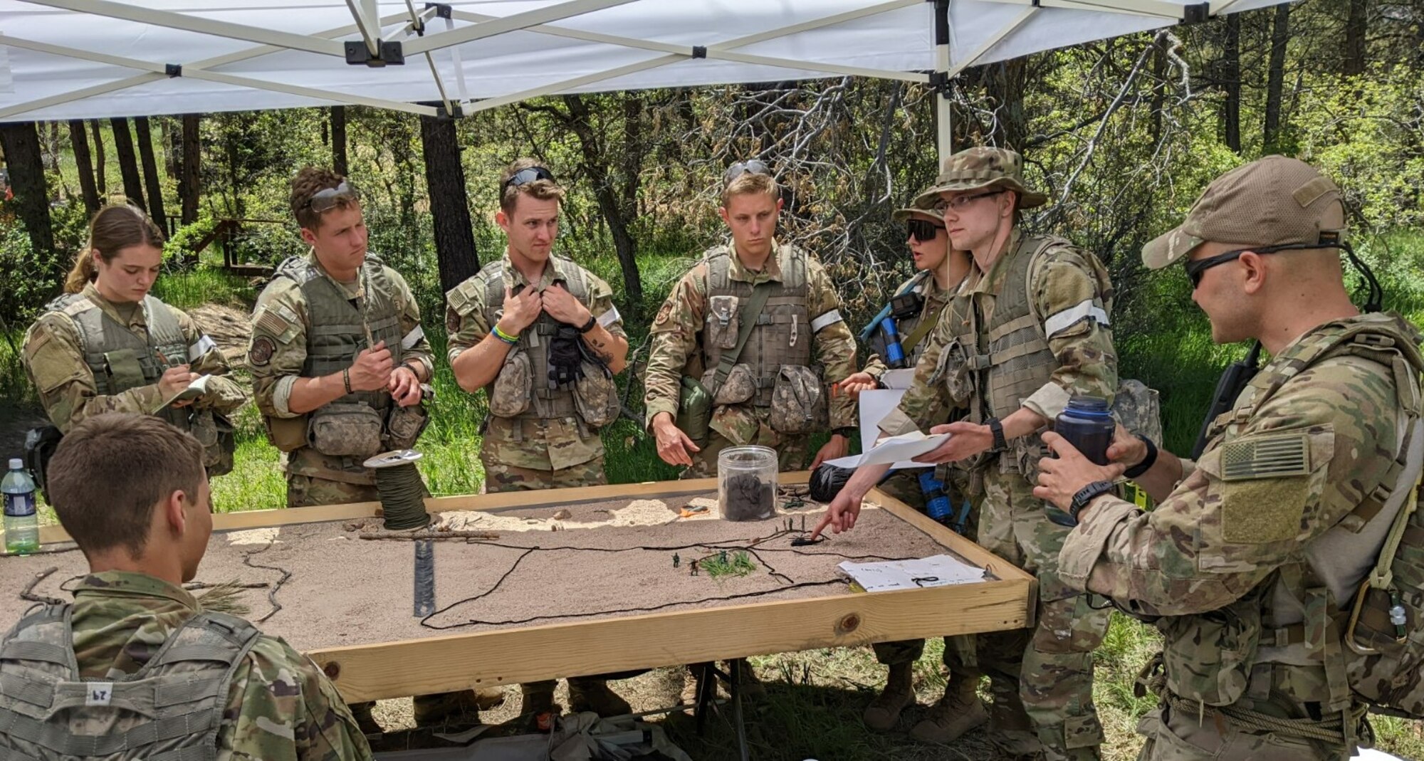 Cadets collectively strategize mission plans as a culmination of the skills learned during the Special Warfare Orientation Course at the U.S. Air Force Academy, Colo., June 13, 2022. Teams of 10 received orders to execute various parts of simulated missions.  Each team planned their actions using troop leading procedures and a sand table then executed the mission. (U.S. Air Force Academy courtesy photo)