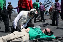 Sailors assigned to the Nimitz-class aircraft carrier USS George H.W. Bush (CVN 77), participate in a mass casualty exercise on the flight deck, Aug. 26, 2022.