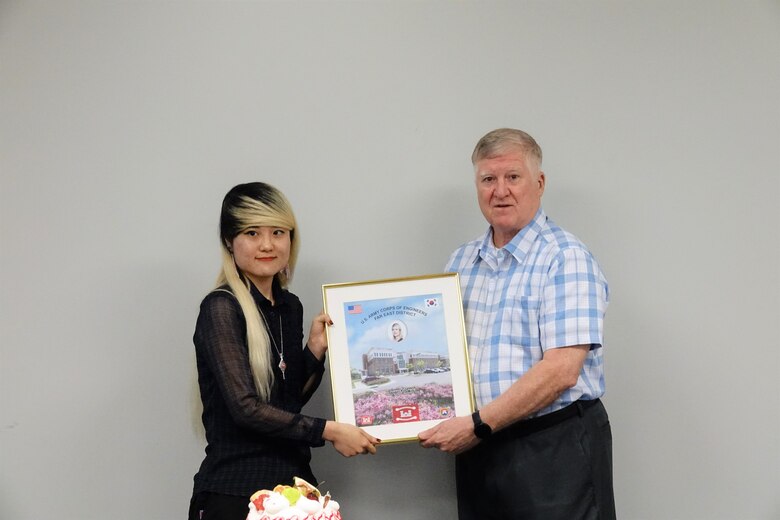 Justina Chang (left), Far East District Workforce Recruitment Program intern, stands with Johnny Howard (right), Information Management Office chief, during her farewell luncheon at the headquarters building, Aug. 12. The Workforce Recruitment Program, or WRP, is a national recruitment program that helps federal sector employers hire college students and recent graduates with disabilities for temporary or permanent positions. (Courtesy photo)